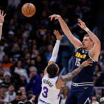 Dec 22, 2025; Denver, Colorado, USA; Denver Nuggets center Nikola Jokic (15) passes the ball as Utah Jazz guard Keyonte George (3) and forward Lauri Markkanen (23) defend in the second quarter at Ball Arena. Mandatory Credit:
