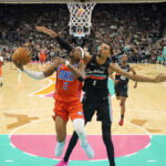 Dec 23, 2025; San Antonio, Texas, USA; Oklahoma City Thunder guard Shai Gilgeous-Alexander (2) drives to the basket past San Antonio Spurs forward Victor Wembanyama (1) during the first half at Frost Bank Center. Mandatory Credit: Scott Wachter-Imagn Images
