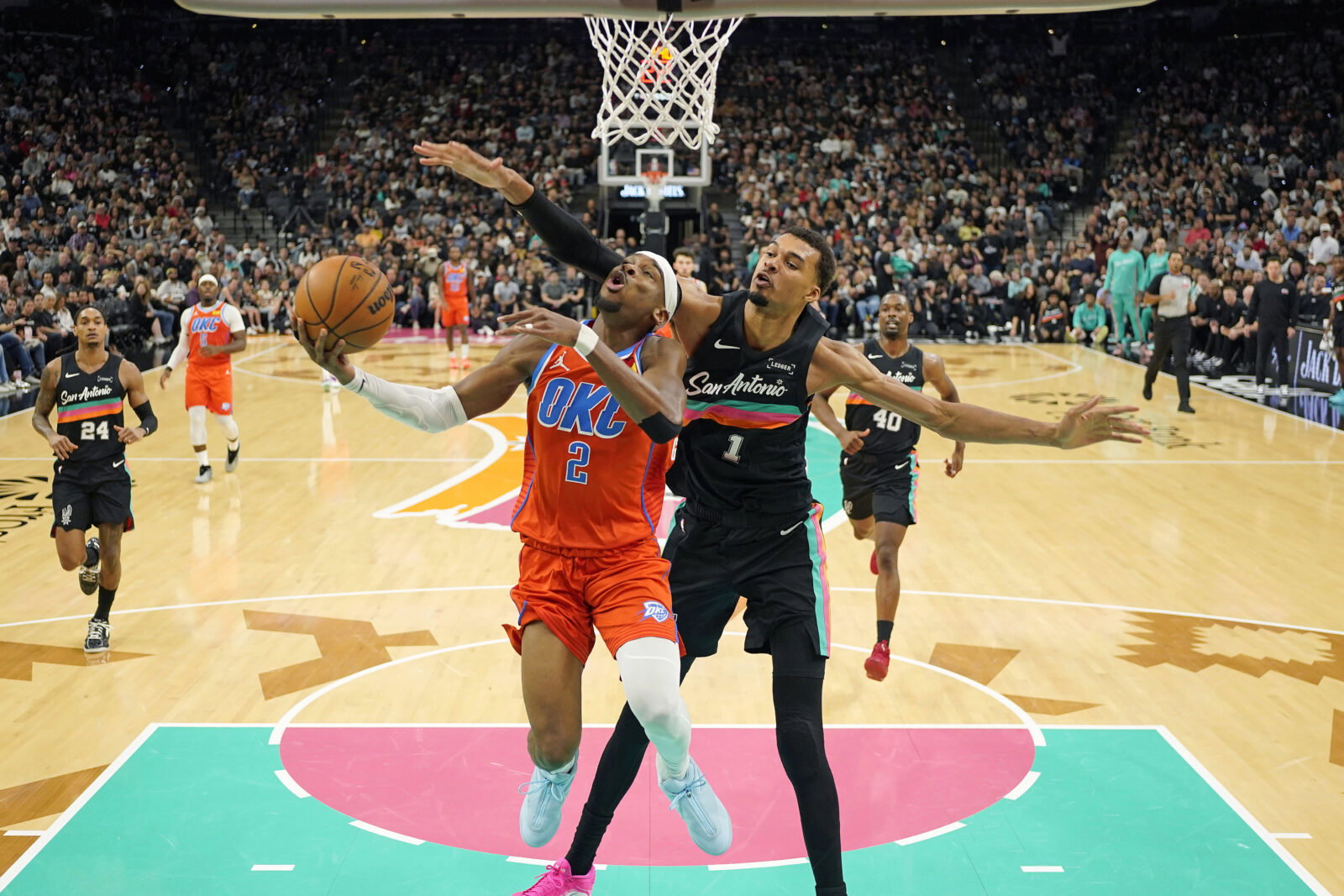 Dec 23, 2025; San Antonio, Texas, USA; Oklahoma City Thunder guard Shai Gilgeous-Alexander (2) drives to the basket past San Antonio Spurs forward Victor Wembanyama (1) during the first half at Frost Bank Center. Mandatory Credit: Scott Wachter-Imagn Images