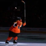 Jan 12, 2026; Philadelphia, Pennsylvania, USA; Philadelphia Flyers mascot Gritty entertains fans with rainbow stick tape for Pride Night before the game against the Tampa Bay Lightning at Xfinity Mobile Arena. Mandatory Credit: Kyle Ross-Imagn Images