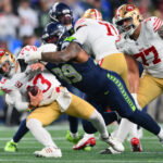 Jan 17, 2026; Seattle, WA, USA; San Francisco 49ers quarterback Brock Purdy (13) is sacked by Seattle Seahawks defensive end Leonard Williams (99) during the second half in an NFC Divisional Round game at Lumen Field.