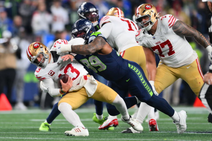 Jan 17, 2026; Seattle, WA, USA; San Francisco 49ers quarterback Brock Purdy (13) is sacked by Seattle Seahawks defensive end Leonard Williams (99) during the second half in an NFC Divisional Round game at Lumen Field.