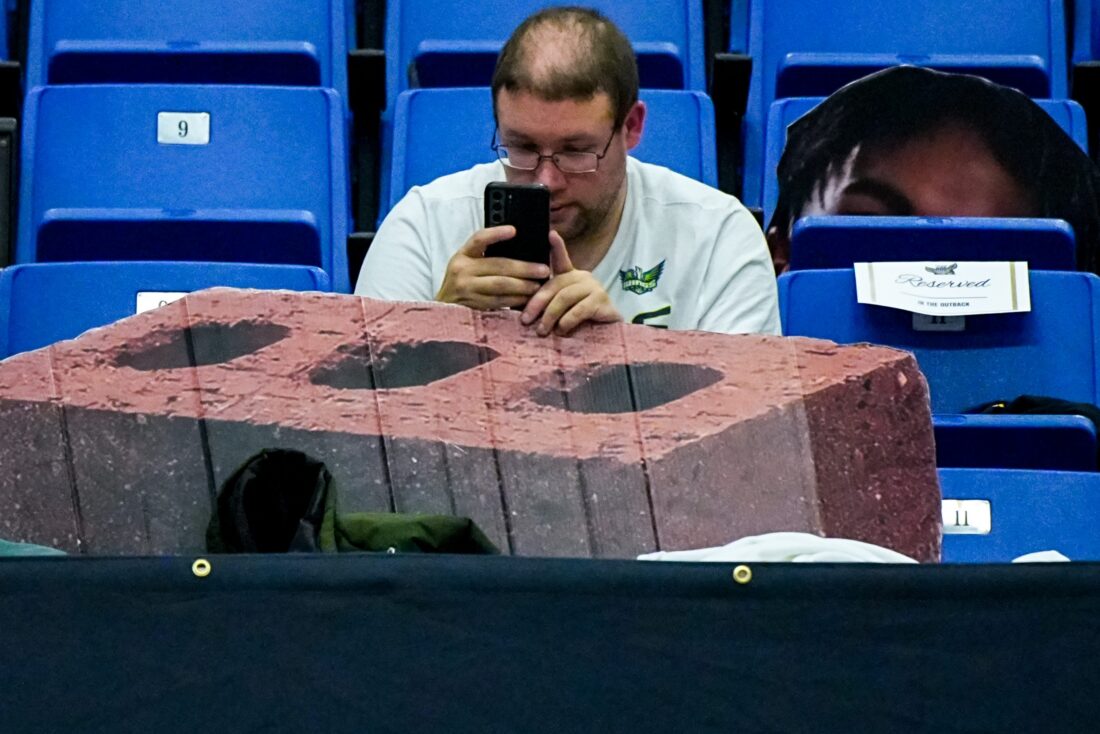A University of Akon basketball fan looks at his phone before the game against Toledo, Jan. 27, 2026, at James A Rhodes Arena in Akron, Ohio.
