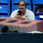 A University of Akon basketball fan looks at his phone before the game against Toledo, Jan. 27, 2026, at James A Rhodes Arena in Akron, Ohio.