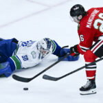 Mar 6, 2026; Chicago, Illinois, USA; Chicago Blackhawks left wing Andrew Mangiapane (26) shoots against Vancouver Canucks goaltender Nikita Tolopilo (60) during the third period at United Center. Mandatory Credit: