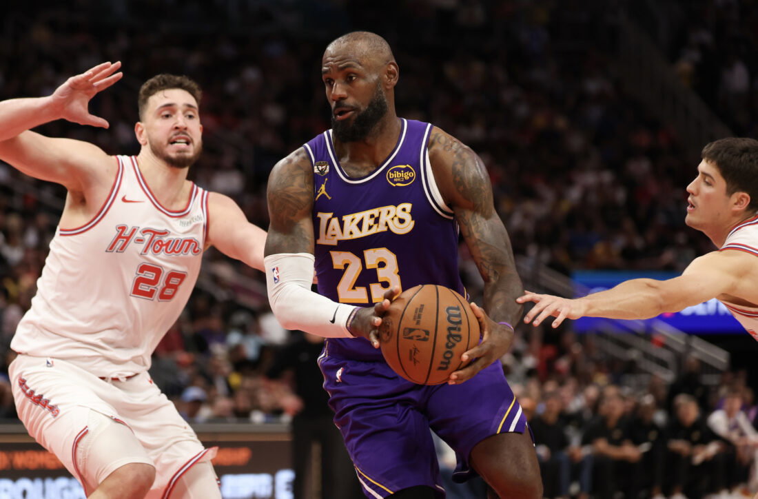 Mar 18, 2026; Houston, Texas, USA; Los Angeles Lakers forward LeBron James (23) splits the defense of Houston Rockets center Alperen Sengun (28) and guard Reed Sheppard (15) in the second half at Toyota Center. Mandatory Credit: Thomas Shea-Imagn Images