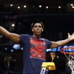 Mar 29, 2026; Washington, DC, USA; UConn Huskies forward Tarris Reed Jr. (5) cuts down the net after defeating the Duke Blue Devils in an Elite Eight game of the East Regional of the men's 2026 NCAA Tournament at Capital One Arena. Mandatory Credit: Geoff Burke-Imagn Images