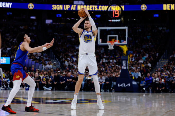 Mar 29, 2026; Denver, Colorado, USA; Golden State Warriors center Kristaps Porzingis (7) attempts a shot as Denver Nuggets guard Julian Strawther (3) defends in the second quarter at Ball Arena.
