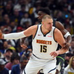 Apr 18, 2026; Denver, Colorado, USA; Denver Nuggets center Nikola Jokic (15) is fouled by Minnesota Timberwolves guard Anthony Edwards (5) as he handles the ball during the first half in game one of the first round of the 2026 NBA Playoffs at Ball Arena.