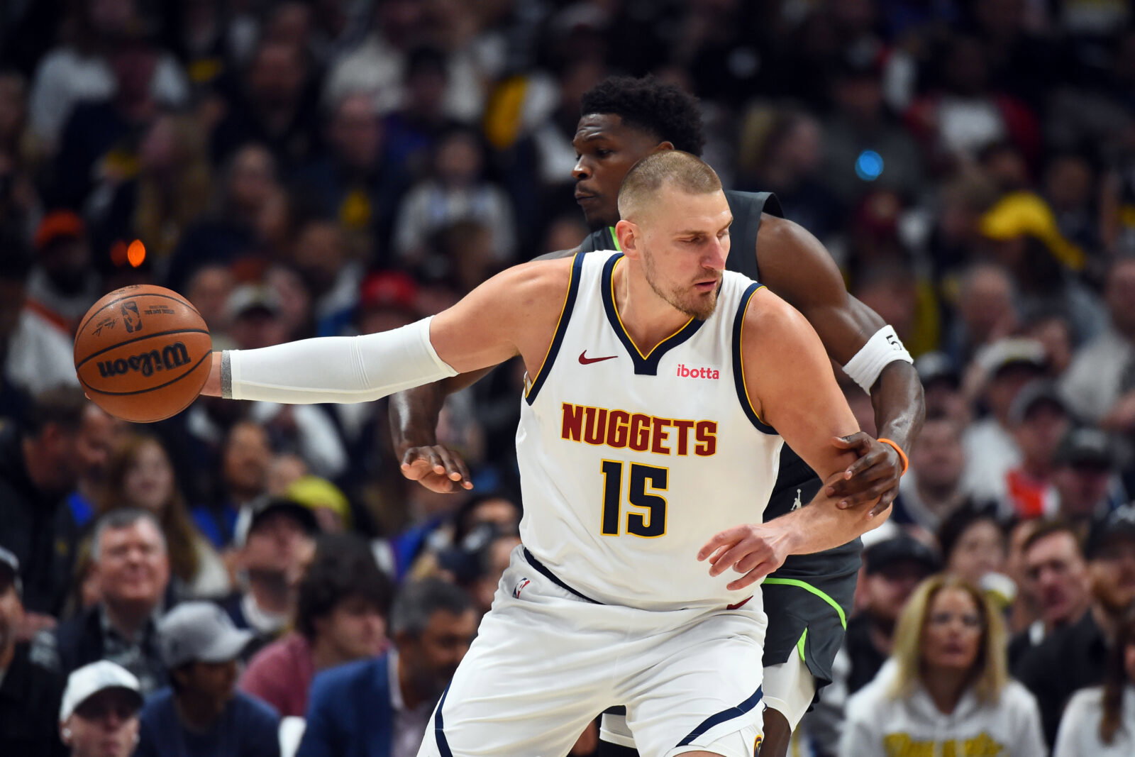 Apr 18, 2026; Denver, Colorado, USA; Denver Nuggets center Nikola Jokic (15) is fouled by Minnesota Timberwolves guard Anthony Edwards (5) as he handles the ball during the first half in game one of the first round of the 2026 NBA Playoffs at Ball Arena.