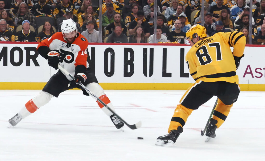 Apr 18, 2026; Pittsburgh, Pennsylvania, USA; Philadelphia Flyers center Sean Couturier (14) moves the puck against Pittsburgh Penguins center Sidney Crosby (87) during the second period in game one of the first round of the 2026 Stanley Cup Playoffs at PPG Paints Arena.