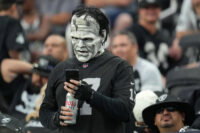 Aug 14, 2022; Paradise, Nevada, USA; A Las Vegas Raiders fan checks his phone during a preseason game between the Raiders and the Minnesota Vikings at Allegiant Stadium. Mandatory Credit: Stephen R. Sylvanie-USA TODAY Sports