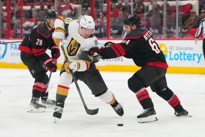 Oct 28, 2025; Raleigh, North Carolina, USA; aVegas Golden Knights left wing Ivan Barbashev (49) skates with the puck against Carolina Hurricanes defenseman Joel Nystrom (64) during the second period t Lenovo Center. Mandatory Credit: James Guillory-Imagn Images