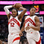 Oct 26, 2025; Dallas, Texas, USA; Toronto Raptors forward Collin Murray-Boyles (12) and forward Scottie Barnes (4) control the ball during the game between the Mavericks and the Raptors at the American Airlines Center. Mandatory Credit: Jerome Miron-Imagn Images