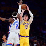 April 7, 2026; Los Angeles, California, USA; Los Angeles Lakers forward Jake LaRavia (12) shoots against Oklahoma City Thunder guard Shai Gilgeous-Alexander (2) during the first half at Crypto.com Arena. Mandatory Credit: