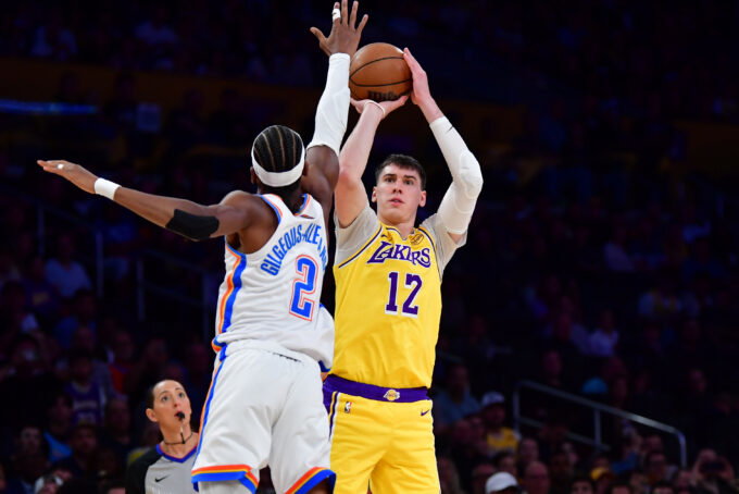 April 7, 2026; Los Angeles, California, USA; Los Angeles Lakers forward Jake LaRavia (12) shoots against Oklahoma City Thunder guard Shai Gilgeous-Alexander (2) during the first half at Crypto.com Arena. Mandatory Credit: