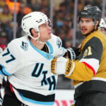 Apr 19, 2026; Las Vegas, Nevada, USA; Vegas Golden Knights center Brett Howden (21) grabs the jersey of Utah Mammoth right wing JJ Peterka (77) during the first period of game one of the first round of the 2026 Stanley Cup Playoffs at T-Mobile Arena. Mandatory Credit: Stephen R. Sylvanie-Imagn Images