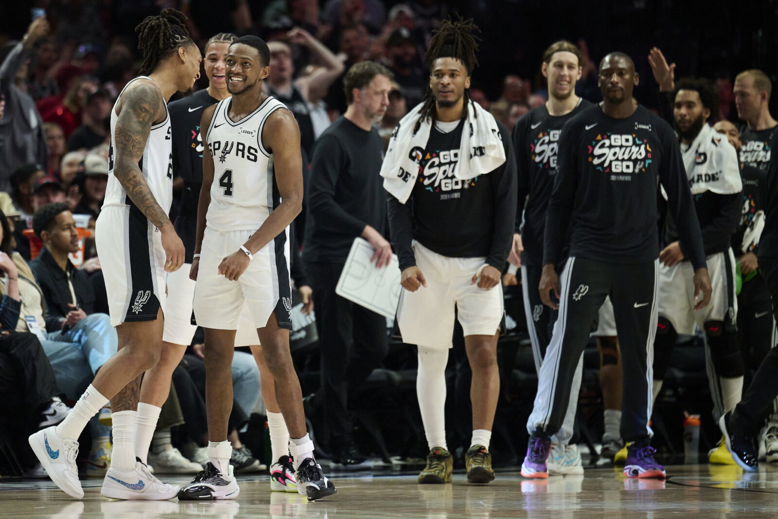 Apr 26, 2026; Portland, Oregon, USA; San Antonio Spurs guard Devin Vassell (24) and guard De'aaron Fox (4) celebrate during a break in the game during the second half against the Portland Trail Blazers during game four of the first round of the 2026 NBA Playoffs at Moda Center. Mandatory Credit: Troy Wayrynen-Imagn Images
