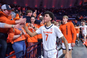 Feb 11, 2025; Champaign, Illinois, USA; Illinois Fighting Illini forward Will Riley (7) and teammates get a hand from the fans after a 83-78 win over the UCLA Bruins at State Farm Center. Mandatory Credit: Ron Johnson-Imagn Images