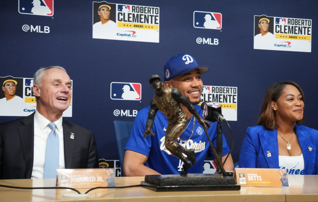 Oct 27, 2025; Los Angeles, California, USA; Los Angeles Dodgers shortstop Mookie Betts (50) is awarded the Roberto Clemente Award by Major League Basesball commissioner Rob Manfred as his wife, Brianna Betts, sits beside him before game three of the 2025 MLB World Series against the Toronto Blue Jays at Dodger Stadium. Mandatory Credit: Kirby Lee-Imagn Images