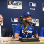 Oct 27, 2025; Los Angeles, California, USA; Los Angeles Dodgers shortstop Mookie Betts (50) is awarded the Roberto Clemente Award by Major League Basesball commissioner Rob Manfred as his wife, Brianna Betts, sits beside him before game three of the 2025 MLB World Series against the Toronto Blue Jays at Dodger Stadium. Mandatory Credit: Kirby Lee-Imagn Images