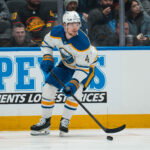 Dec 11, 2025; Vancouver, British Columbia, CAN; Buffalo Sabres defenseman Bowen Byram (4) handles the puck against the Vancouver Canucks in the first period at Rogers Arena. Mandatory Credit: Bob Frid-Imagn Images