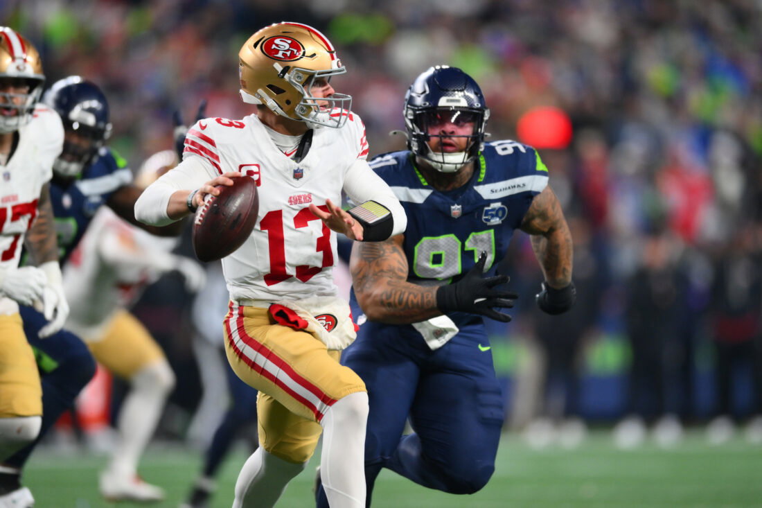 Jan 17, 2026; Seattle, WA, USA; San Francisco 49ers quarterback Brock Purdy (13) is pressured by Seattle Seahawks defensive tackle Byron Murphy II (91) during the second half in an NFC Divisional Round game at Lumen Field. Mandatory Credit: Steven Bisig-Imagn Images