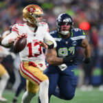 Jan 17, 2026; Seattle, WA, USA; San Francisco 49ers quarterback Brock Purdy (13) is pressured by Seattle Seahawks defensive tackle Byron Murphy II (91) during the second half in an NFC Divisional Round game at Lumen Field. Mandatory Credit: Steven Bisig-Imagn Images