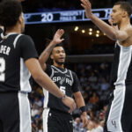 Mar 25, 2026; Memphis, Tennessee, USA; San Antonio Spurs guard Stephon Castle (5) reacts with guard Dylan Harper (2) and forward Victor Wembanyama (1) during the first quarter against the Memphis Grizzlies at FedExForum. Mandatory Credit: Petre Thomas-Imagn Images