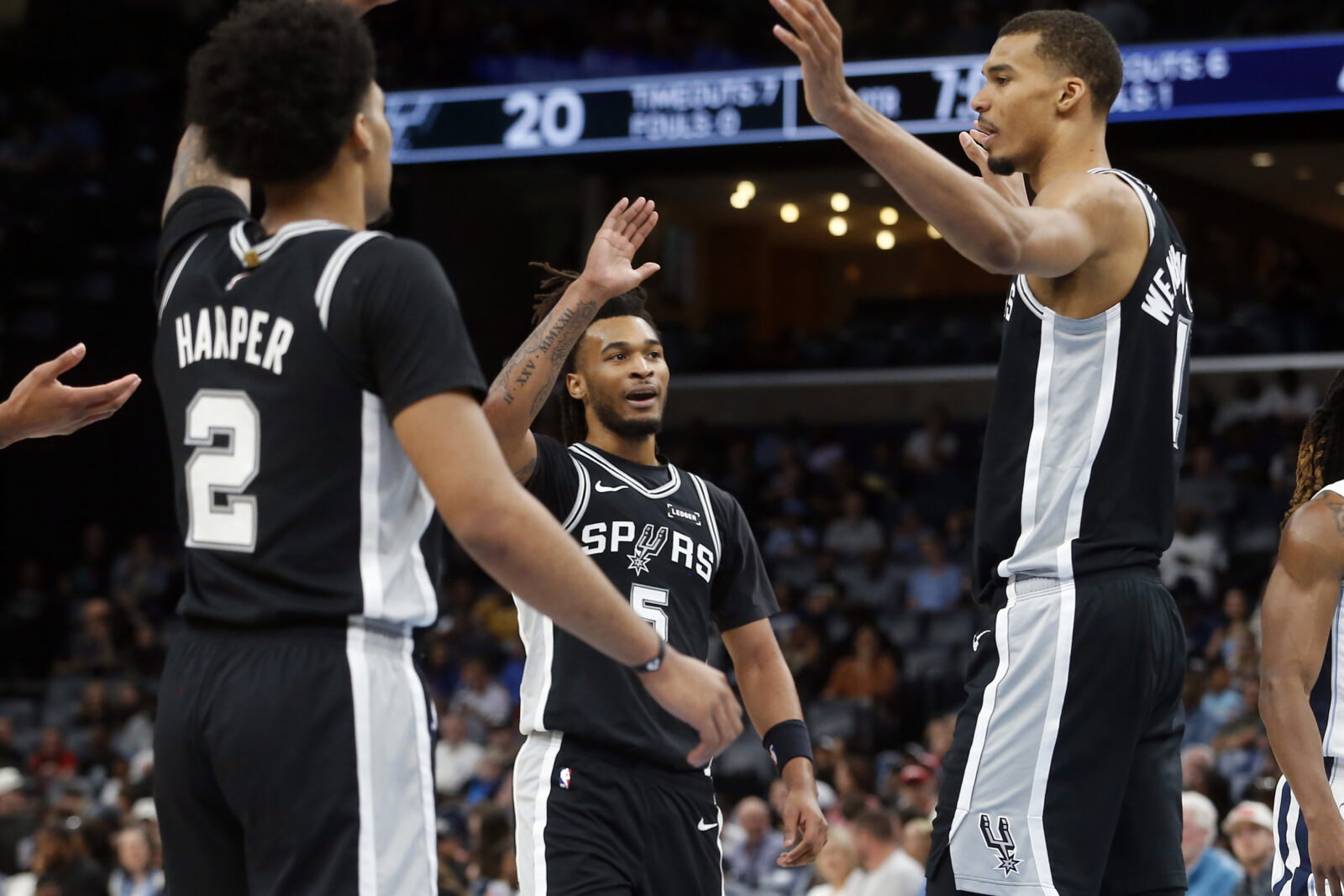 Mar 25, 2026; Memphis, Tennessee, USA; San Antonio Spurs guard Stephon Castle (5) reacts with guard Dylan Harper (2) and forward Victor Wembanyama (1) during the first quarter against the Memphis Grizzlies at FedExForum. Mandatory Credit: Petre Thomas-Imagn Images