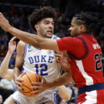 Mar 27, 2026; Washington, DC, USA; Duke Blue Devils forward Cameron Boozer (12) attempts to dribble the ball past St. John's Red Storm forward Bryce Hopkins (23) in the first half during a Sweet Sixteen game of the East Regional of the men's 2026 NCAA Tournament at Capital One Arena. Mandatory Credit: Amber Searls-Imagn Images