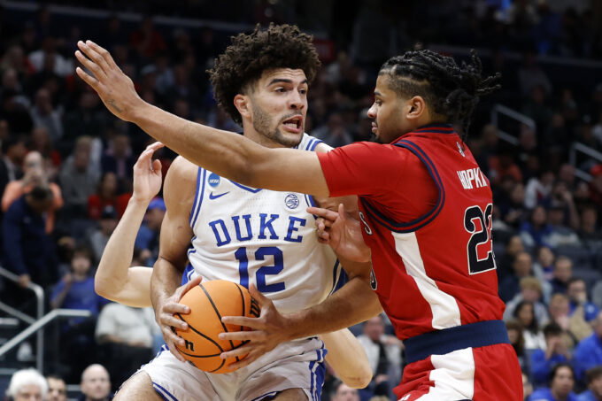 Mar 27, 2026; Washington, DC, USA; Duke Blue Devils forward Cameron Boozer (12) attempts to dribble the ball past St. John's Red Storm forward Bryce Hopkins (23) in the first half during a Sweet Sixteen game of the East Regional of the men's 2026 NCAA Tournament at Capital One Arena. Mandatory Credit: Amber Searls-Imagn Images