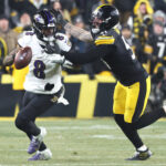 Jan 4, 2026; Pittsburgh, Pennsylvania, USA; Baltimore Ravens quarterback Lamar Jackson (8) scrambles with the ball as Pittsburgh Steelers linebacker Nick Herbig (51) cases during the fourth quarter at Acrisure Stadium. Mandatory Credit: Charles LeClaire-Imagn Images