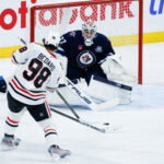 Mar 3, 2026; Winnipeg, Manitoba, CAN; Winnipeg Jets goalie Connor Hellebuyck (37) makes a save against Chicago Blackhawks forward Connor Bedard (98) during the second period at Canada Life Centre. Mandatory Credit: Terrence Lee-Imagn Images
