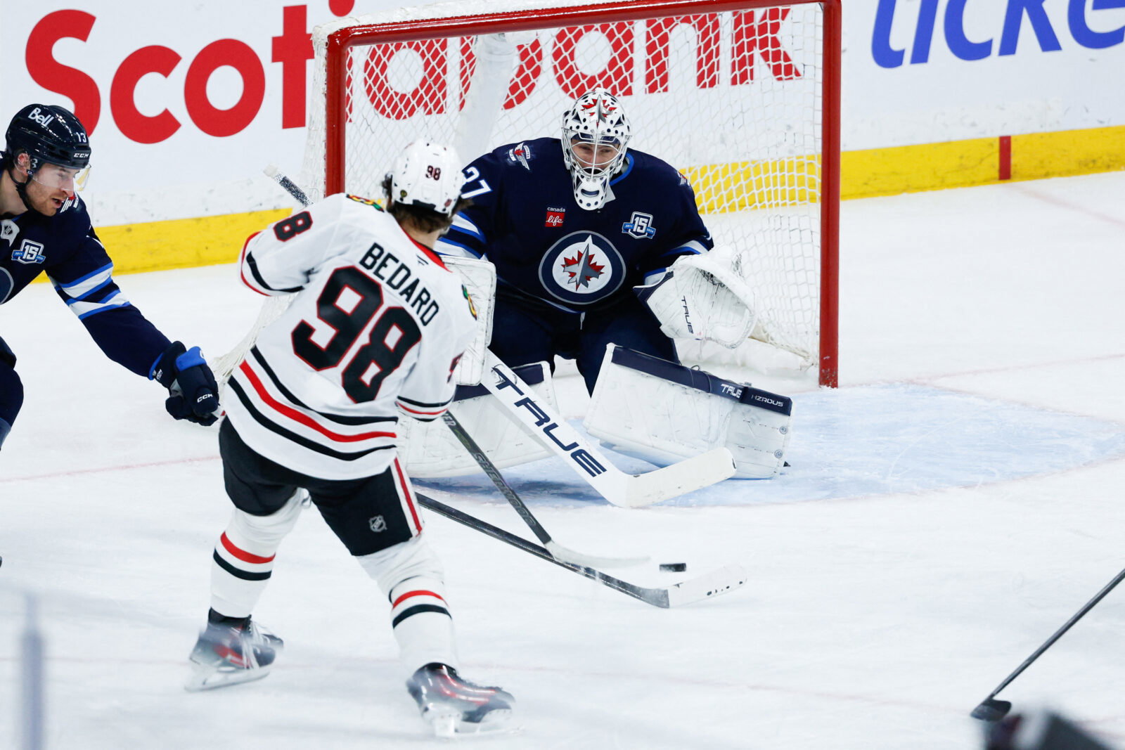 Mar 3, 2026; Winnipeg, Manitoba, CAN; Winnipeg Jets goalie Connor Hellebuyck (37) makes a save against Chicago Blackhawks forward Connor Bedard (98) during the second period at Canada Life Centre. Mandatory Credit: Terrence Lee-Imagn Images