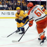 Apr 16, 2026; Nashville, Tennessee, USA; Anaheim Ducks left wing Cutter Gauthier (61) shoots the puck as Nashville Predators defenseman Ryan Ufko (85) defends during the third period of their game at Bridgestone Arena. Mandatory Credit: Alan Poizner-Imagn Images
