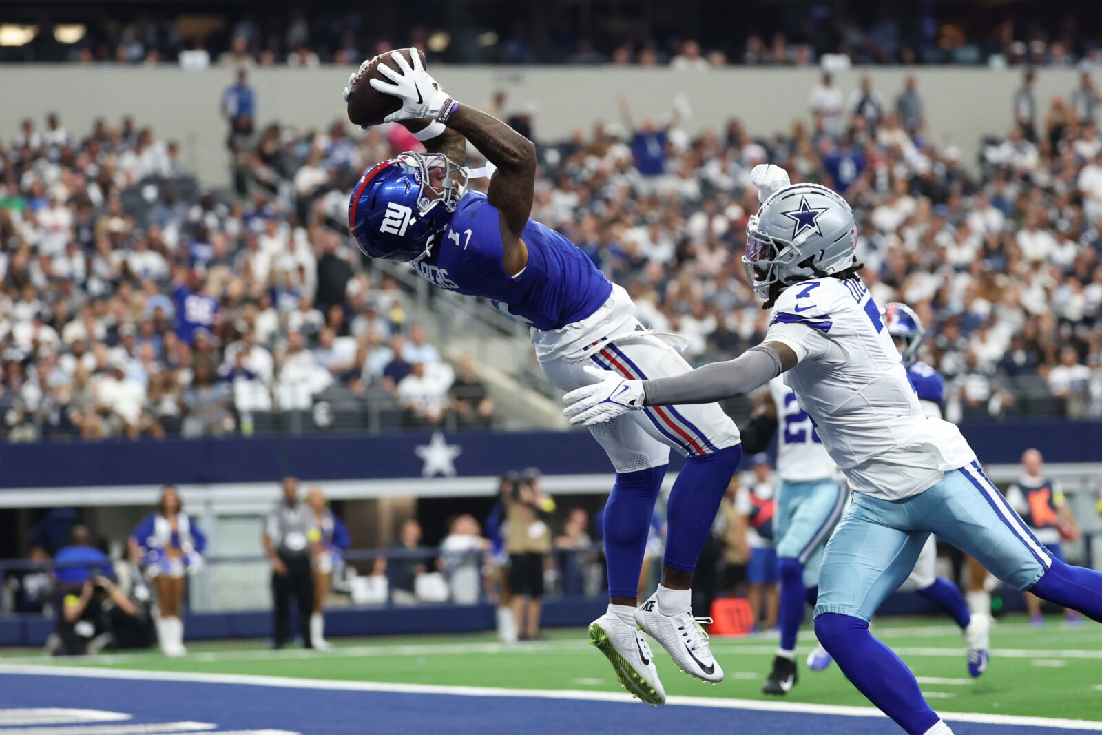 Sep 14, 2025; Arlington, Texas, USA; New York Giants wide receiver Malik Nabers (1) makes a catch for a touchdown against Dallas Cowboys cornerback Trevon Diggs (7) during the second quarter at AT&T Stadium. Mandatory Credit: Kevin Jairaj-Imagn Images