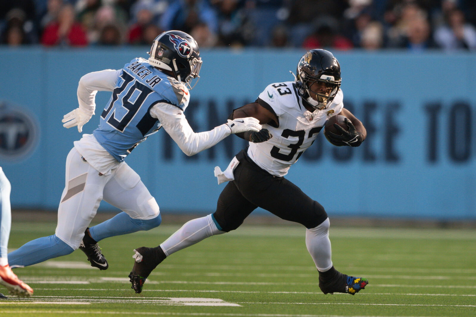 Nov 30, 2025; Nashville, Tennessee, USA; Jacksonville Jaguars running back Bhayshul Tuten (33) runs with the ball against the Tennessee Titans during the second half at Nissan Stadium. Mandatory Credit: Steve Roberts-Imagn Images