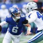 Jan 4, 2026; East Rutherford, New Jersey, USA; New York Giants quarterback Jaxson Dart (6) comes under pressure from Dallas Cowboys defensive end Jadeveon Clowney (42) during the first quarter at MetLife Stadium. Mandatory Credit: Vincent Carchietta-Imagn Images