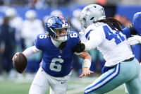 Jan 4, 2026; East Rutherford, New Jersey, USA; New York Giants quarterback Jaxson Dart (6) comes under pressure from Dallas Cowboys defensive end Jadeveon Clowney (42) during the first quarter at MetLife Stadium. Mandatory Credit: Vincent Carchietta-Imagn Images