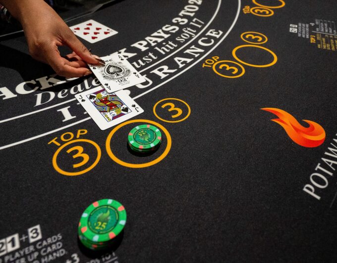 A table games dealer places cards on a blackjack table.