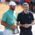Jul 14, 2026; Southport, England; Scottie Scheffler returns the Claret Jug to CEO of The R&A Mark Darbon (R) in a ceremony during a practice day for The Open Championship golf tournament at Royal Birkdale. Mandatory Credit: Bill Streicher-Imagn Images