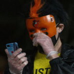 Apr 24, 2021; Baltimore, Maryland, USA; A fan wearing a Baltimore Orioles mask looks towards their phone during the game against the Oakland Athletics at Oriole Park at Camden Yards. Mandatory Credit: Tommy Gilligan-USA TODAY Sports