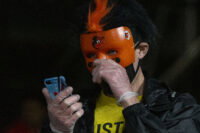 Apr 24, 2021; Baltimore, Maryland, USA; A fan wearing a Baltimore Orioles mask looks towards their phone during the game against the Oakland Athletics at Oriole Park at Camden Yards. Mandatory Credit: Tommy Gilligan-USA TODAY Sports