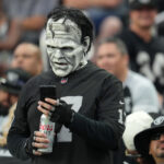 Aug 14, 2022; Paradise, Nevada, USA; A Las Vegas Raiders fan checks his phone during a preseason game between the Raiders and the Minnesota Vikings at Allegiant Stadium. Mandatory Credit: Stephen R. Sylvanie-USA TODAY Sports