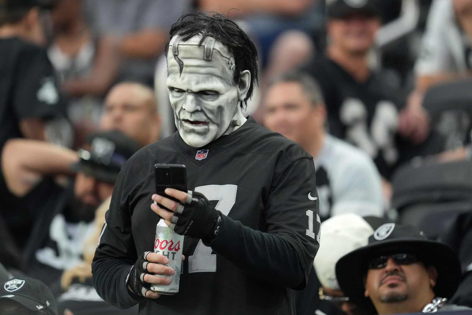 Aug 14, 2022; Paradise, Nevada, USA; A Las Vegas Raiders fan checks his phone during a preseason game between the Raiders and the Minnesota Vikings at Allegiant Stadium. Mandatory Credit: Stephen R. Sylvanie-USA TODAY Sports