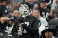 Aug 14, 2022; Paradise, Nevada, USA; A Las Vegas Raiders fan checks his phone during a preseason game between the Raiders and the Minnesota Vikings at Allegiant Stadium. Mandatory Credit: Stephen R. Sylvanie-USA TODAY Sports