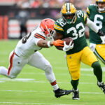 Aug 10, 2024; Cleveland, Ohio, USA; Green Bay Packers running back MarShawn Lloyd (32) runs with the ball as Cleveland Browns linebacker Caleb Johnson (48) defends during the second half at Cleveland Browns Stadium. Mandatory Credit: Ken Blaze-USA TODAY Sports