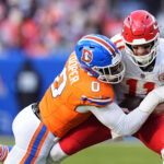 Jan 5, 2025; Denver, Colorado, USA; Denver Broncos linebacker Jonathon Cooper (0) sacks Kansas City Chiefs quarterback Carson Wentz (11) in the second quarter at Empower Field at Mile High. Mandatory Credit: Ron Chenoy-Imagn Images