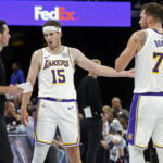 Oct 31, 2025; Memphis, Tennessee, USA; Los Angeles Lakers head coach JJ Redick talks with guard Austin Reaves (15) and guard Luka Doncic (77) during the fourth quarter against the Memphis Grizzlies at FedExForum. Mandatory Credit: Petre Thomas-Imagn Images